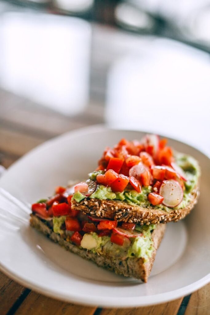Delicious sandwiches with avocado and juicy tomato slices on rye bread pieces with sesame seeds